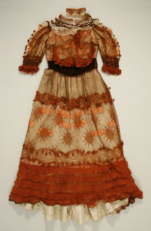 Ein hellfarbenes Kleid mit hohem Kragen, langen Ärmeln und einem langen Rock, der bis zum Boden reicht, mit detaillierten Mustern und leuchtenden Farben, auf einem weißen Hintergrund in einem Museum.
