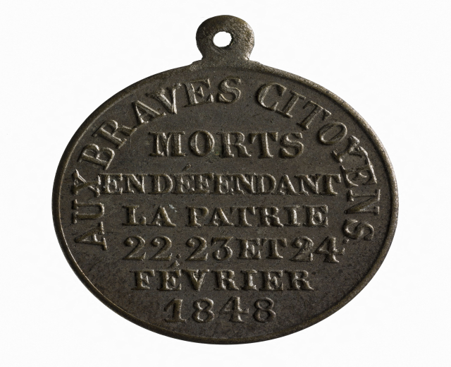 Bronzene Medaille mit "Braves City Morts" eingraviert, vor einem weißen Hintergrund.