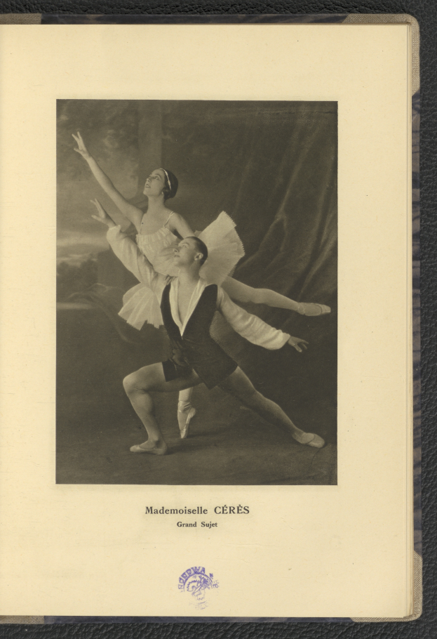 Ein Schwarz-Weiß-Foto eines Mannes und einer Frau in Ballettkleidung, die perfekt synchron tanzen, wobei der Mann ein weißes Tutu trägt und die Frau ein rosafarbenes Kleid trägt, mit Text am unteren Bildrand.