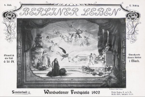 Ein Schwarz-Weiß-Foto einer Bühne der Wiesbadener Festspiele 1902, das Menschen in traditioneller deutscher Kleidung zeigt, einige mit Hüten und andere mit Umhängen, unter bunten Lichtern und Dekorationen, während das Publikum im Hintergrund jubelt und klatscht.