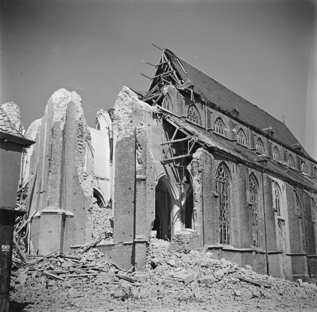 Schwarzes und weißes Foto einer zerstörten Kirche mit zerbrochenen Mauern, Schutt und sichtbarem Himmel darüber.