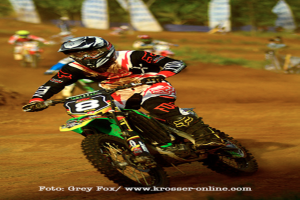 Mehrere Personen bei Motorradrennen, alle mit Helmen, mit Text unten im Bild.