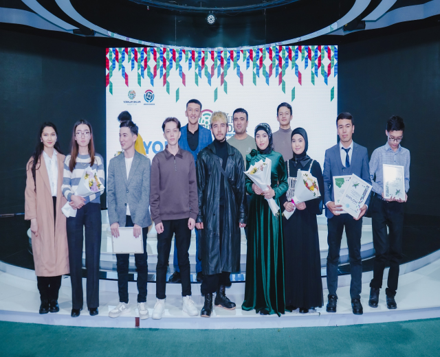 Gruppe von Menschen auf einer Bühne mit Blumensträußen und Urkunden, vor einem Hintergrund mit der Aufschrift "Jugend-Solar-Awards 2019"