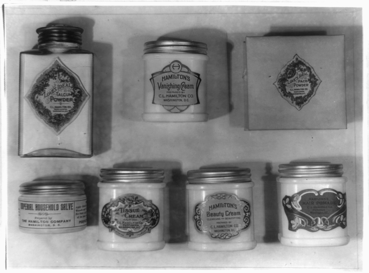 Schwarzes und weißes Foto eines Regals mit ordentlich angeordneten Creme-Gläsern, jedes mit einer anderen Art beschriftet.