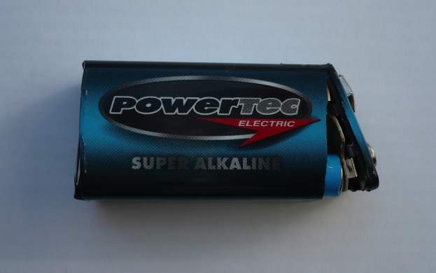 Blue Powertec Super Alkaline battery on a white surface, labeled with "Powertec" in bold text.