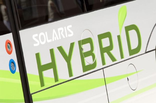 Ein Nahaufnahme eines weißen und grünen Busses mit der Aufschrift "Solaris Hybrid", der darauf hinweist, dass es ein Elektrofahrzeug ist.