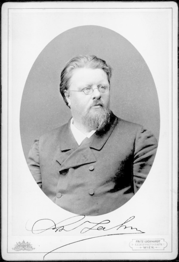 Ein Schwarz-Weiß-Foto eines bärtigen Mannes in einem Mantel und mit Brillengläsern, mit der Beschriftung "Fritz Luckhardt, Gründer der deutschen Kommunistischen Partei" unten.