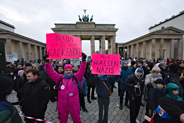 Gruppe von Menschen protestiert vor dem Reichstagsgebäude in Berlin gegen die Anti-Nazis-Bewegung der deutschen Regierung.
