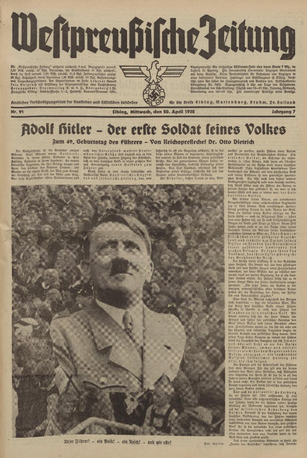 Adolf Hitler, gekleidet in einen schwarzen Anzug und ein weißes Hemd, steht vor einer Menge auf der Titelseite einer deutschen Zeitung mit der Überschrift "Adolf Hitler - Der Erte Soldat Feines Volkes".
