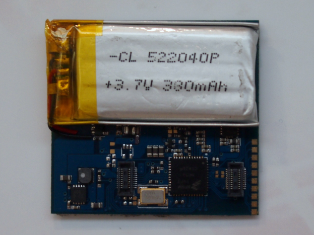 Nahaufnahme einer Mobiltelefonbatterie mit aufgedrucktem Text auf einer Leiterplatte auf einer weißen Oberfläche.