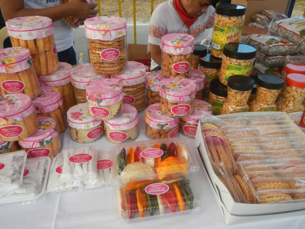 Gruppe von Menschen um einen Tisch mit verschiedenen Speisen bei einem Outdoor-Food-Festival.