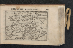 Ein aufgeschlagenes Buch, das eine detaillierte Landkarte von Westfalen zeigt, auf einer schwarzen Oberfläche.